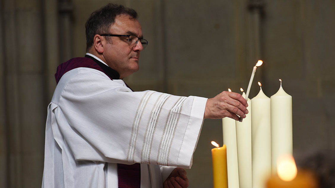 Pfarrer Hans-Bernd Köppen entzündet vier Kerzen auf dem Altar der St.-Lamberti-Kirche in Münster.