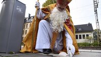 Ein verkleideter Nikolaus sammelt Müll auf