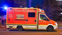 Ein Krankenwagen mit Blaulicht fährt auf einer Straße.