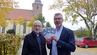 Bernd Strickmann, Pfarrer von Cloppenburg St. Andreas, und Günther Kannen vom Pfarreirat stellen das Projekt Glaubensjahr Memory vor.