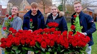 Messdienerleiter verteilen rote Rosen