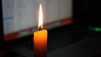 Kerze vor einem Computerbildschirm