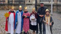 Fünf als Könige verkleidete Kinder umringen Bischof Felix Genn.