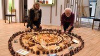 Die beiden Ehrenamtlichen Brigitte Stanzel (links) und Roland Lünnemann haben in der „Kirche im Stern“ ein Mandala zum Thema Erntedank gelegt.