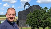 Pfarrer Lars-Jörg Bratke vor der 2012 geweihten St.-Marien-Kirche.