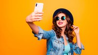 Eine junge Frau macht ein Selfie mit dem Handy
