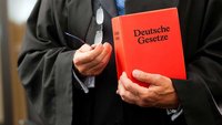 Richter mit Gesetzbuch in der Hand.