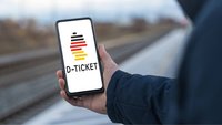 Eine Person hält ein Handy in der Hand, auf der das Deutschlandticket abgebildet ist.