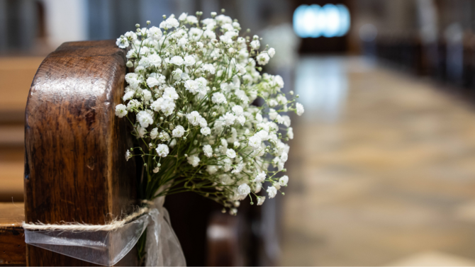 Blumenstrauß an einer Kirchenbank