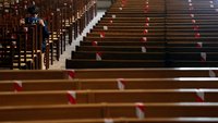 In der Kirche Saint-Francois-Xavier in Paris sitzt ein Mann mit Mund-Nasen-Schutz allein in den Kirchenbänken.