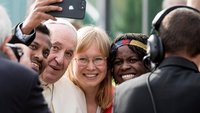 Jugendliche machen ein Selfie mit Papst Franziskus