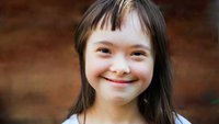 Ein lächelndes Kind mit Down-Syndrom