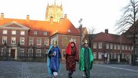 Drei Kinder gehen als Sternsinger über den münsterschen Domplatz.