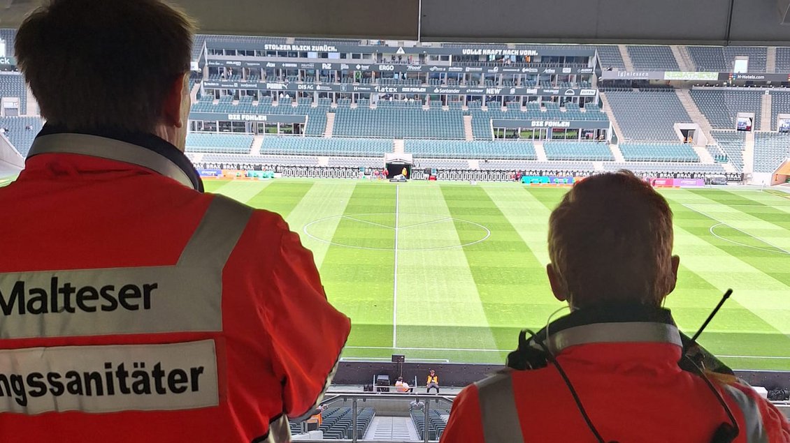 Zwei Rettungssanitäter auf einer Tribüne im Fußballstadion Foto: Malteser