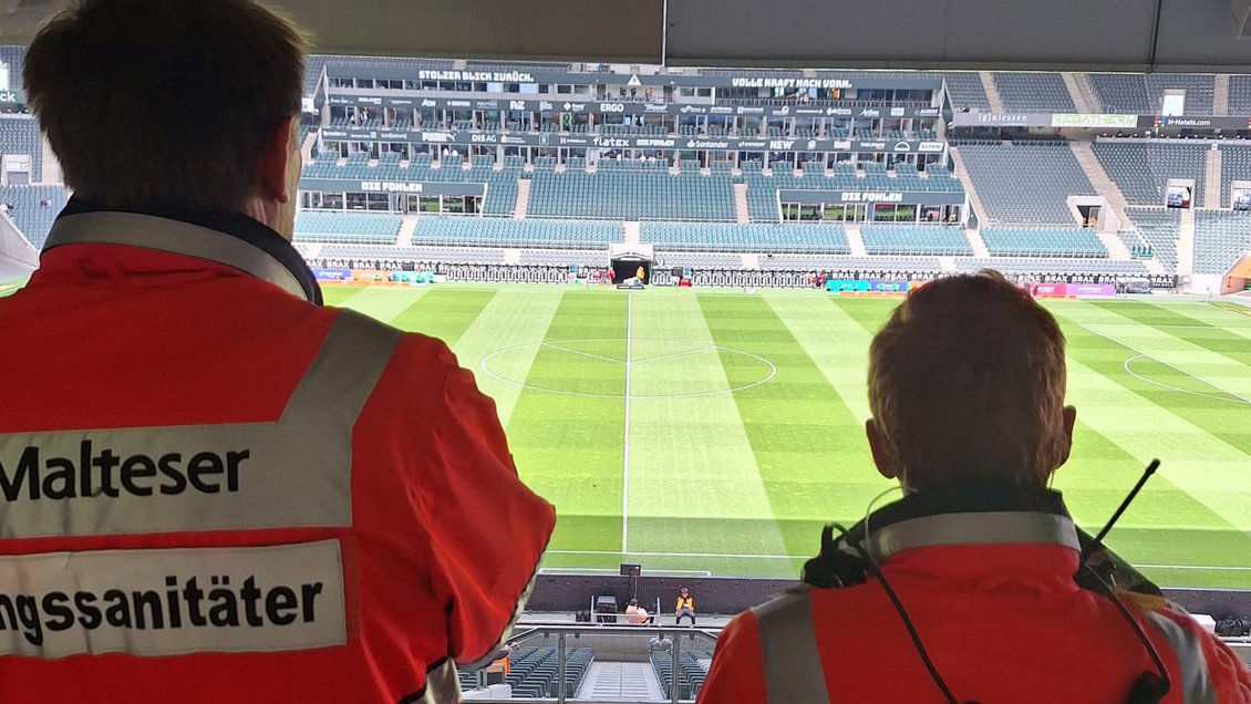 Zwei Rettungssanitäter auf einer Tribüne im Fußballstadion