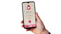 Eine Hand hält ein Smartphone. Auf der Oberfläche des Smartphones leuchtet der Startbildschirm der neuen Firm-App.