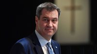 Markus Söder vor einem Kreuz