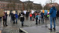 Martin Schulte steht auf einem Podium auf dem Domplatz und spricht zu den Demonstrationsteilnehmern.