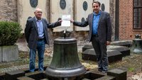 Hans Manek und Thomas Flammer mit der Glocke