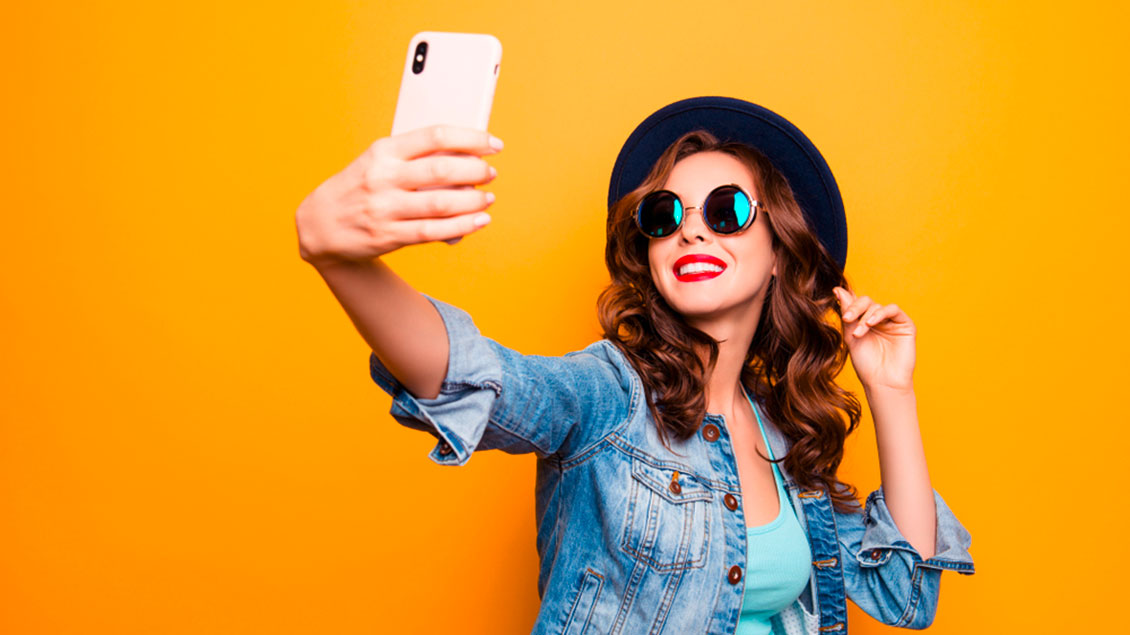 Eine junge Frau macht ein Selfie mit dem Handy