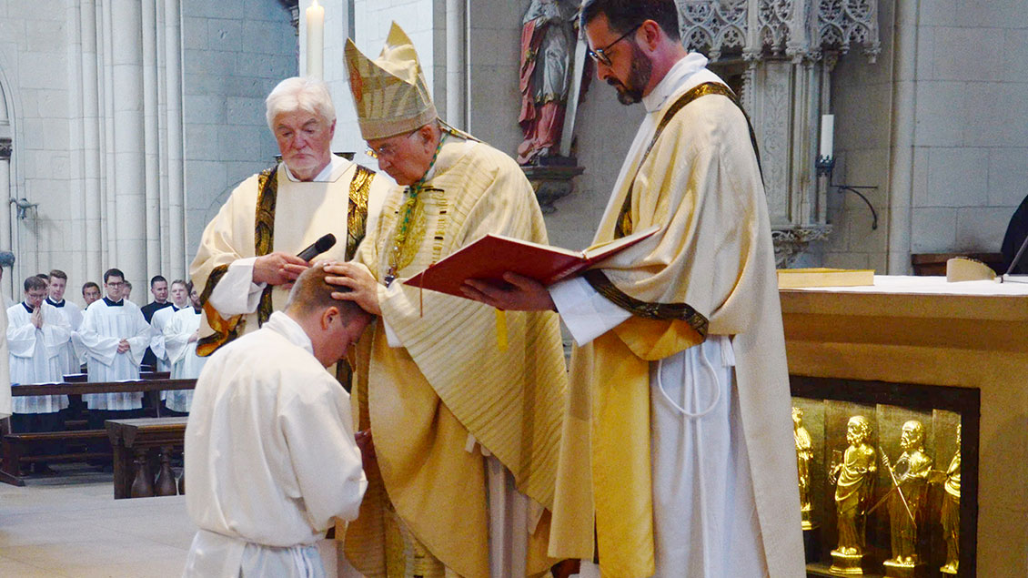 Durch stille Handauflegung und Gebet weiht Bischof Felix Genn den Priesteramtskandidaten Jonas Mieves im Paulusdom zum Diakon.