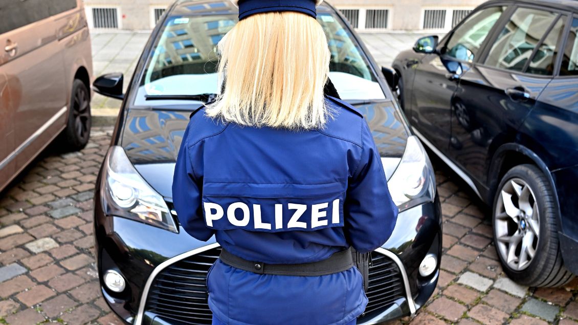 Eine Polizistin steht vor einem Auto.