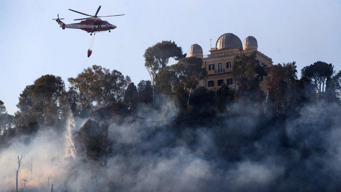 Mit Löschwasser aus dem Tiber bekämpfen Hubschrauber ein Feuer an einem nahgelegenen Kloster.