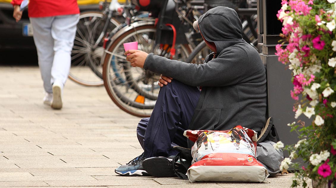 Ein Obdachloser bettelt um Kleingeld