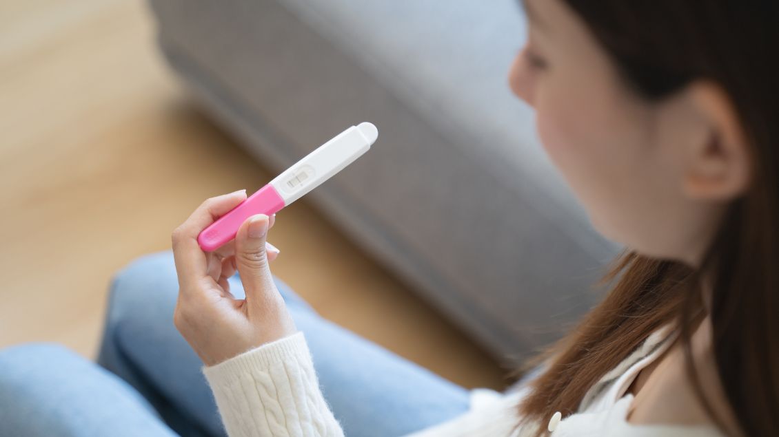 Frau mit Schwangerschaftstest in der Hand